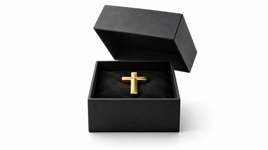 An open charcoal gift box holding a gold cross on white, symbolising salvation freely given.