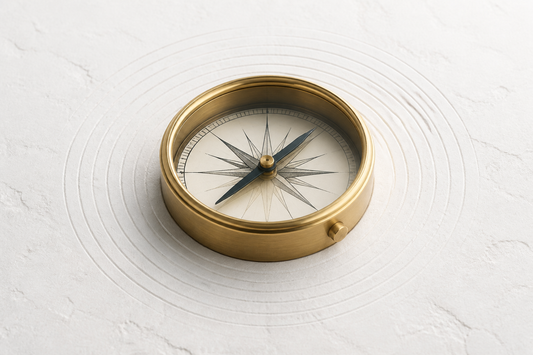 A precision brass compass resting steadily on a white stone surface surrounded by subtle concentric lines