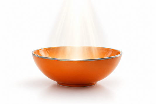 An orange ceramic vessel receiving white light against a clean white background, representing prayer and humble intention