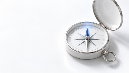 A silver and white compass with an unmarked face and a blue needle on a clean white background