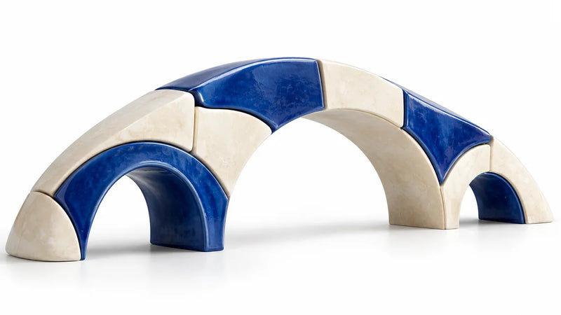 Distinct ivory and cobalt arches joined into one sculptural bridge